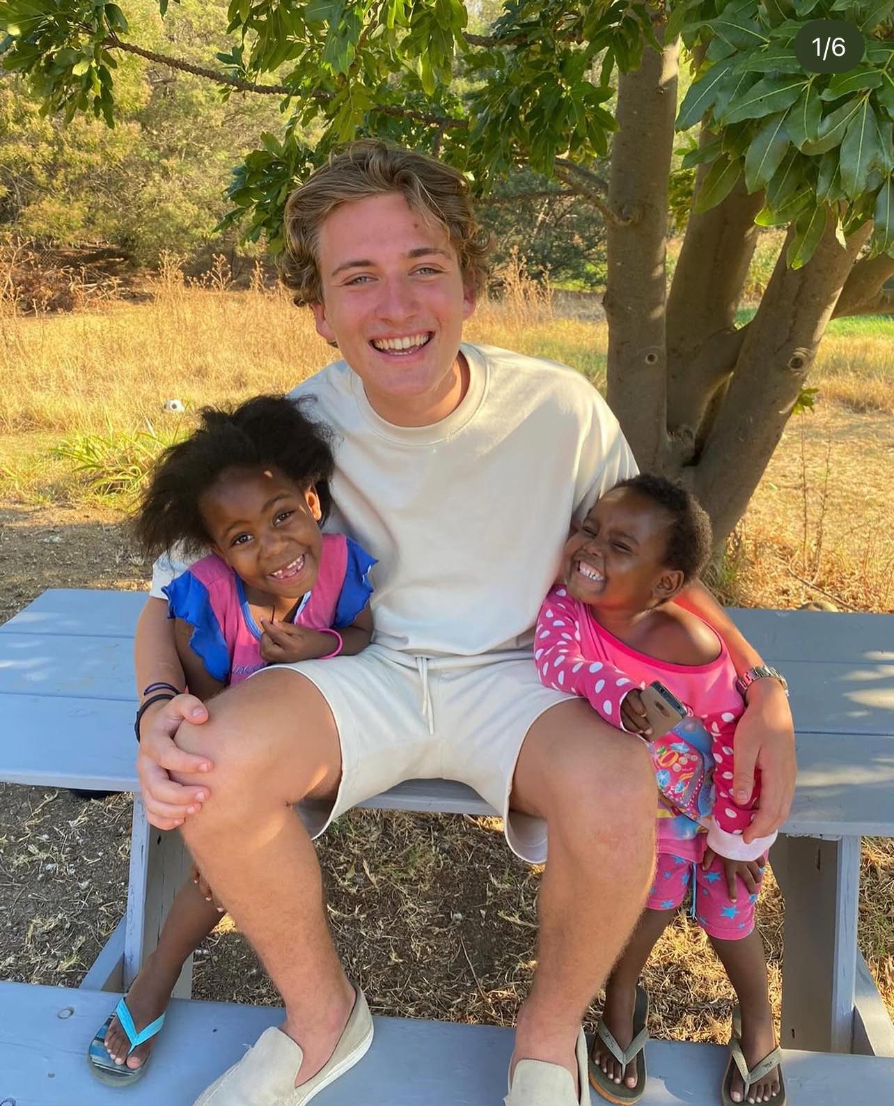 Maarten buiten op een bankje met twee jonge kinderen